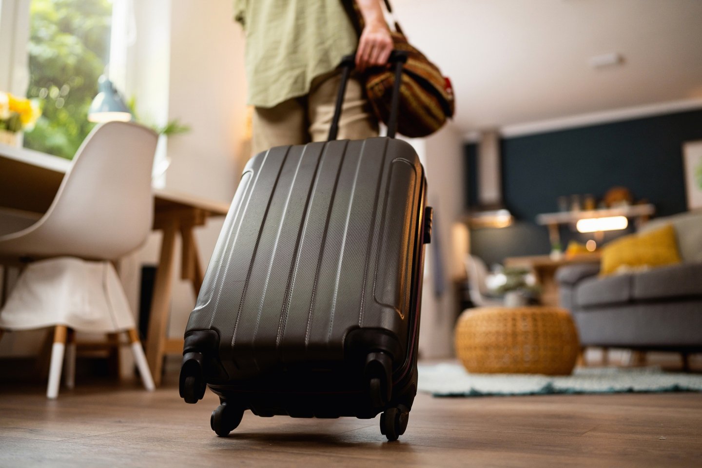 Person wheeling a suitcase before they take a flight or holiday booked online with webjet