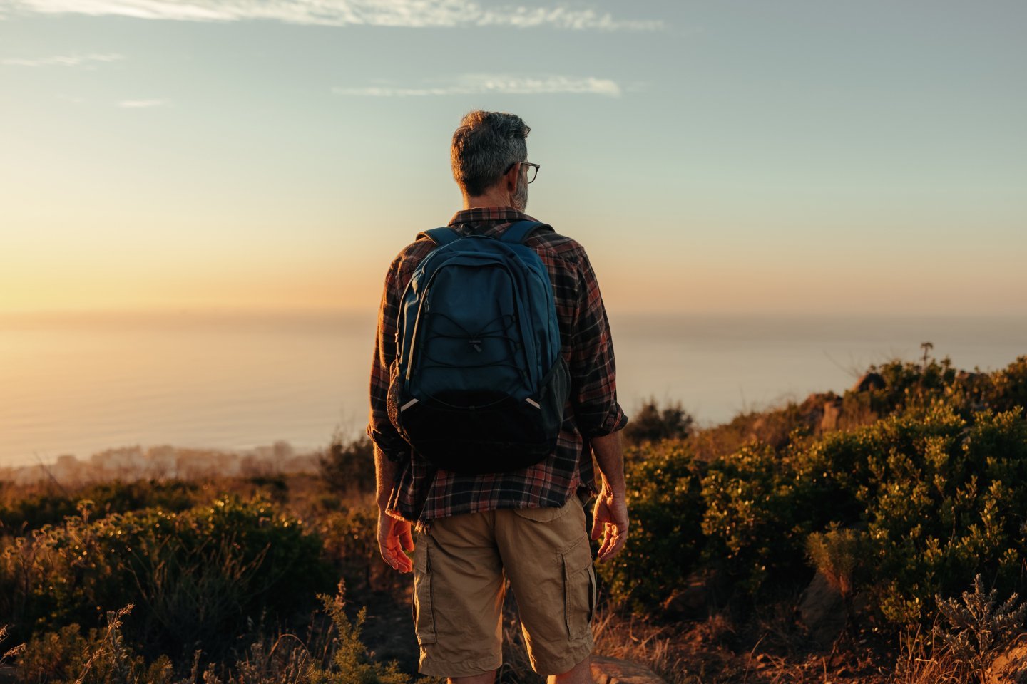 man in his 50s hiking at sunset and thinking about a fulfilling retirement
